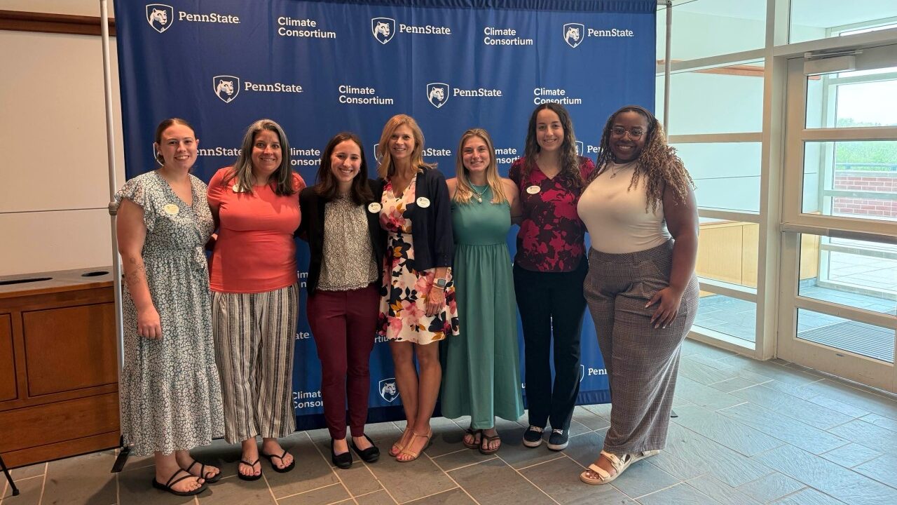 Rachel Cole stands with colleagues in front of a Penn State Climate Consortium backdrop during the 2026 Climate Solutions Symposium.