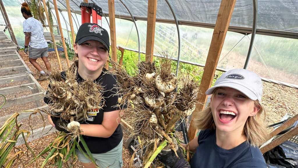 Arboretum interns holding crops at the student farm