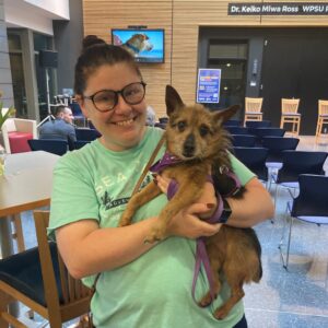 Volunteer poses with adoptable dog