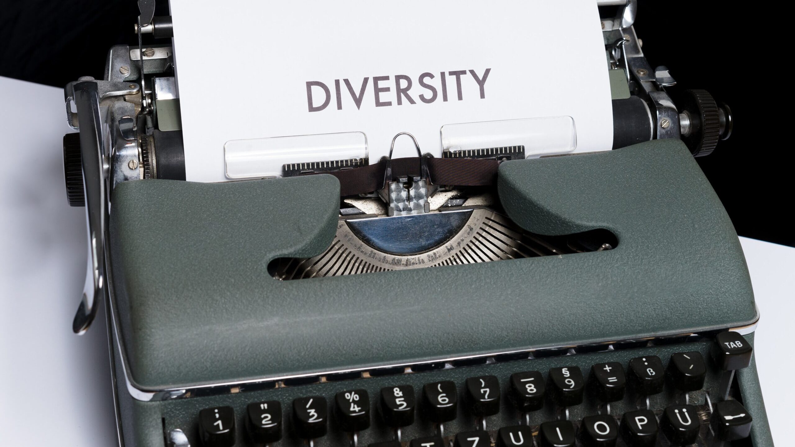 An old black typewriter with a page emerging that says, "Diversity"